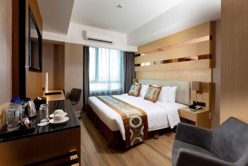 a hotel room with a bed and a chair at Best Western Plus Metro Clark in Angeles