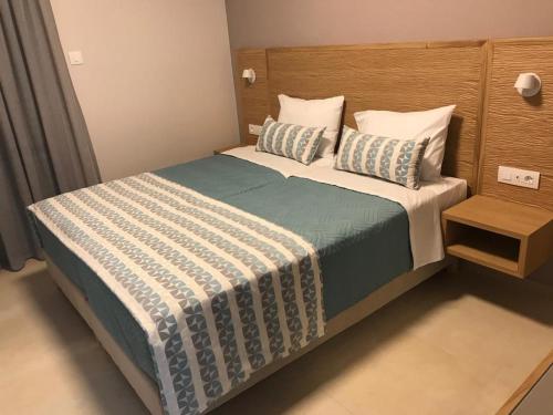 a bedroom with a bed with a blue and white blanket at Maria Beach Hotel in Kissamos