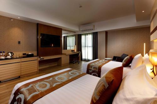 a hotel room with two beds and a flat screen tv at Best Western Plus Metro Clark in Angeles