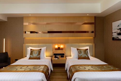 a hotel room with two beds and a desk at Best Western Plus Metro Clark in Angeles