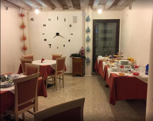 una sala da pranzo con tavoli e un orologio sul muro di Al Bagolaro a Crocetta del Montello