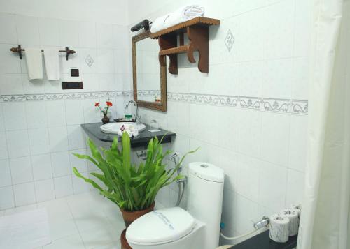 een badkamer met een toilet, een wastafel en een spiegel bij Soma Manaltheeram Ayurveda BeachVillage in Kovalam