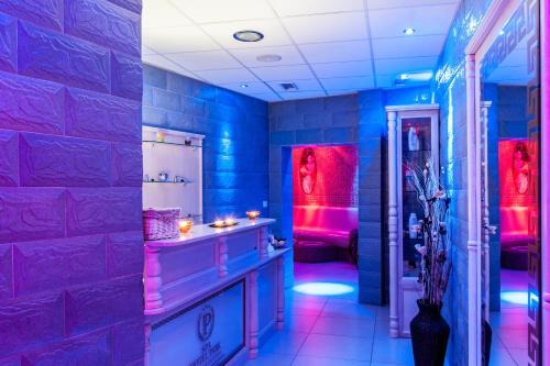 y baño con luces y paredes de color azul y púrpura. en Hotel Park Bachinovo en Blagoevgrad