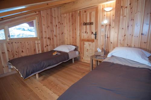 a bedroom with two beds in a wooden cabin at Chalet Marie-Rose in Veysonnaz
