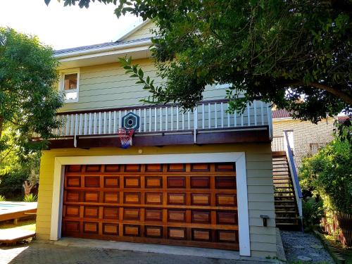 a garage door with a balcony on top of a house at Whales & Waves in Port Alfred