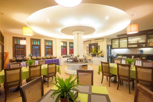 a restaurant with tables and chairs and a large ceiling at Vdara Pool Resort Spa Chiang Mai in Chiang Mai