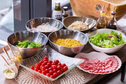 a table topped with bowls of different types of food at Hotel Monterey Le Frere Osaka in Osaka