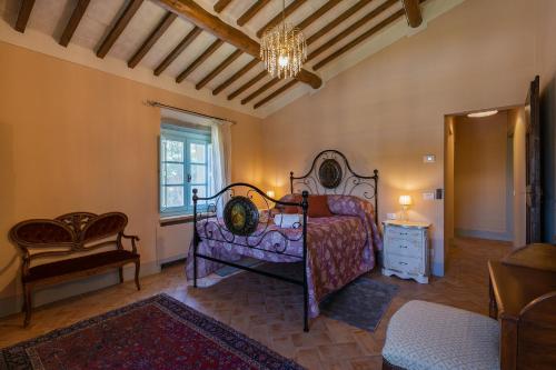 a bedroom with a bed and a chandelier at Villa Mezzavia in Cortona