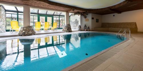 a large swimming pool in a large room with at Alpenwellnesshotel Gasteigerhof in Neustift im Stubaital