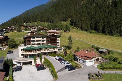 an aerial view of a hotel with cars parked in a parking lot at Hotel Gasteigerhof in Neustift im Stubaital