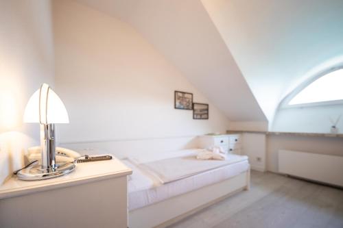 a bedroom with a bed and a desk with a lamp at Hotel Linde in Maria Wörth