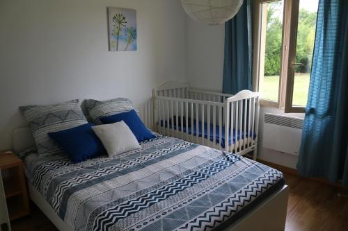 a bedroom with a bed with blue pillows and a window at Le Camp De Ferie in Monpazier