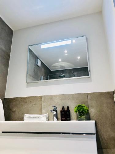 a mirror above a sink in a bathroom at Blue City Apartments in Lübeck