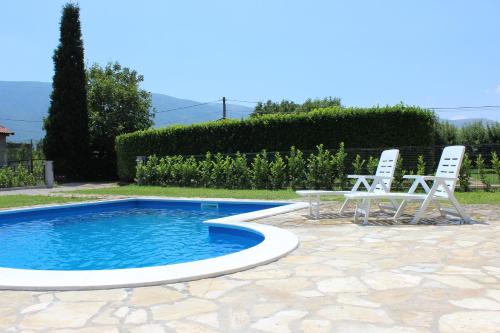 two chairs and a table next to a swimming pool at Villa Mirna in Mostar