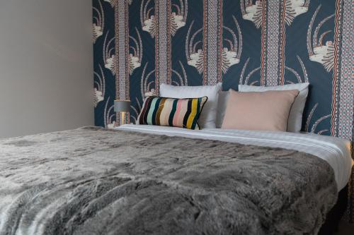 um quarto com uma cama grande e uma parede azul em Smartflats - Pot d'Or em Liège