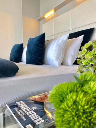a couch with blue and white pillows on it at Blue City Apartments in Lübeck