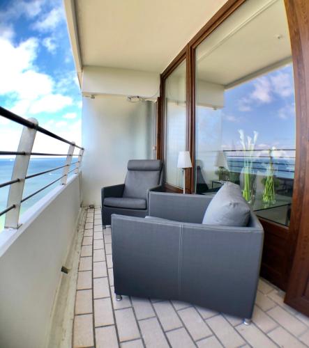 a balcony with a couch and a chair and a window at Blue City Apartments in Lübeck
