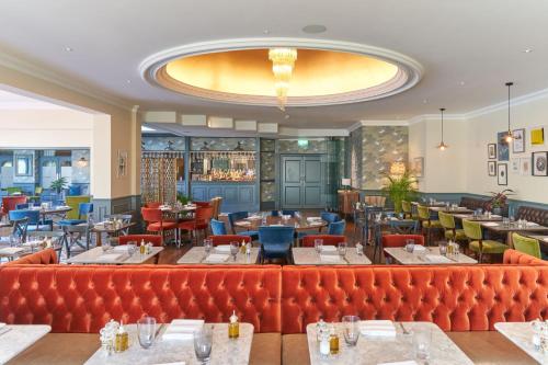 a restaurant with a red couch in the middle at Best Western Plus The Connaught Hotel and Spa in Bournemouth