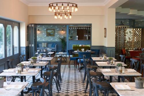 a restaurant with tables and chairs and a chandelier at Best Western Plus The Connaught Hotel and Spa in Bournemouth