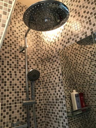 a shower with a shower head in a bathroom at Studio Tour Eiffel in Paris