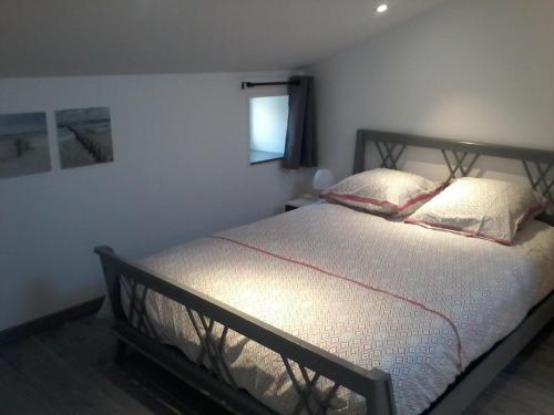 1 dormitorio con 1 cama con 2 almohadas y ventana en Gîte climatisé *** Le Pigeonnier, en Pons