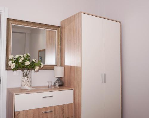 La salle de bains est pourvue d'une armoire et d'un vase de fleurs. dans l'établissement Cozy home in Thessaloniki center, à Thessalonique