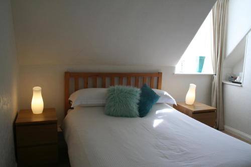 a bedroom with a bed with two lamps and a pillow at The Cross Keys Hotel in New Galloway