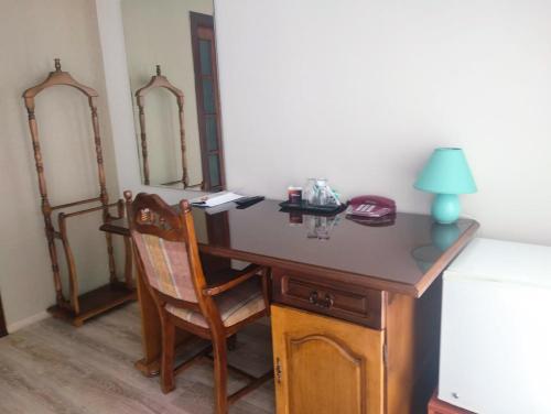a wooden desk with a chair and a lamp on it at Hotel Villa Natali in Chişinău