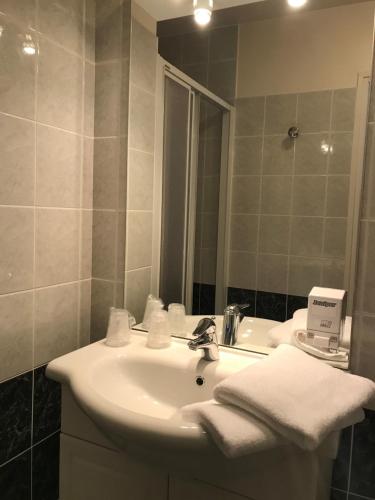 y baño con lavabo y espejo. en Hôtel La Colombiere Cantal, en Massiac