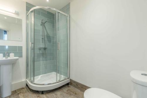 uma casa de banho com um chuveiro, um WC e um lavatório. em Modern apartment within short walk of The Castle, High Street and Long Walk - FREE PARKING em Windsor