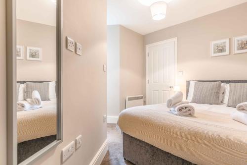 a bedroom with two beds and a large mirror at Modern apartment within short walk of The Castle, High Street and Long Walk - FREE PARKING in Windsor