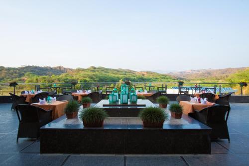 a restaurant with tables and chairs on a balcony at Golden Tulip Chandigarh, Panchkula in Chandīgarh