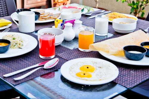 Una mesa cubierta con platos de desayuno y bebidas. en X by Bloom l Indiranagar, en Bangalore