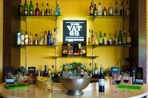 a bar with a bunch of bottles of alcohol at Golden Tulip Chandigarh, Panchkula in Chandīgarh