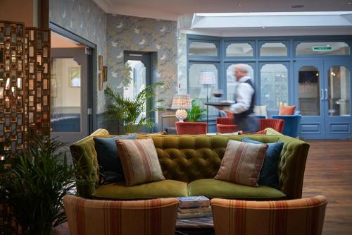 a green couch in a store with a man walking in the background at Connaught Lodge in Bournemouth