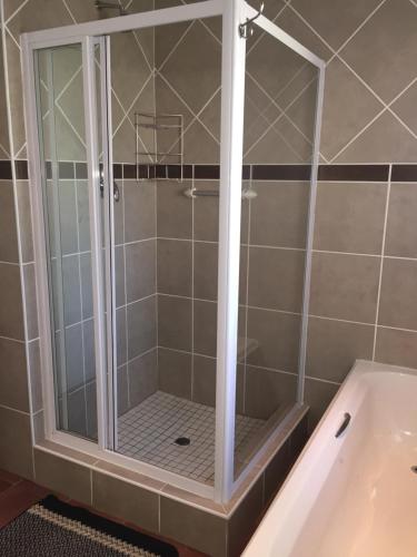 a shower with a glass door in a bathroom at Welcome Guest House in Vereeniging