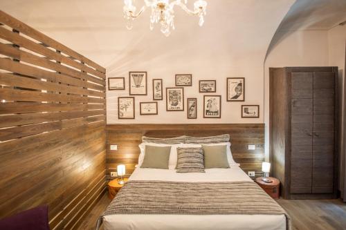 a bedroom with a large bed and a chandelier at La Canonica - charming self-catering apartments in Nizza Monferrato in Nizza Monferrato