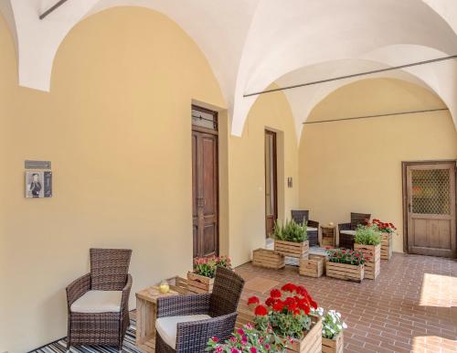 a patio with chairs and potted plants at La Canonica - charming self-catering apartments in Nizza Monferrato in Nizza Monferrato