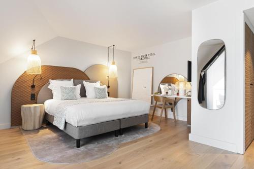 a bedroom with a large bed and a table at Black Bass Hotel in Sévrier