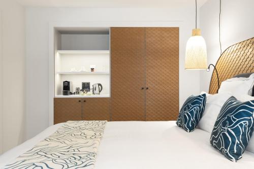 a bedroom with a bed and a cupboard at Black Bass Hotel in Sévrier