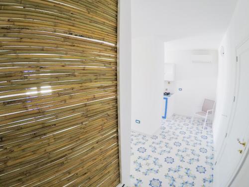 baño con pared de madera y aseo en Gyaaim, en Castro di Lecce