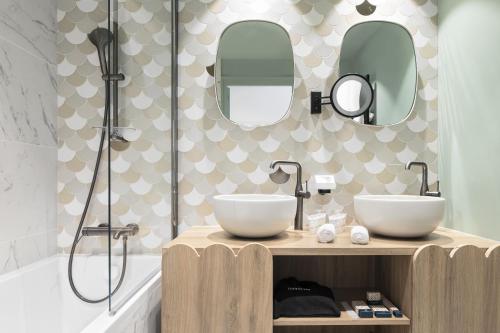 a bathroom with two sinks and two mirrors at Black Bass Hotel in Sévrier