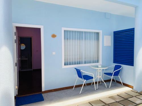 a room with a table and chairs and a window at Hudhuvelimaldives in Omadhoo