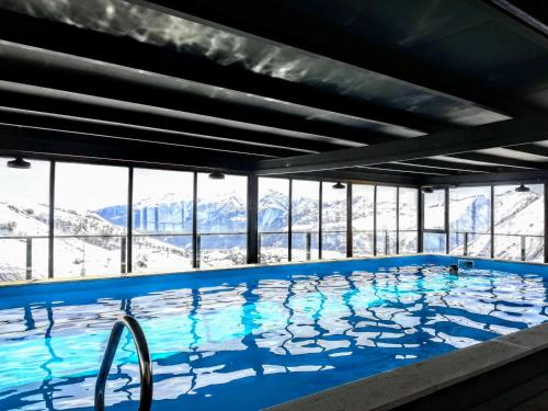 a large swimming pool with mountains in the background at Apartment N503 Gudauri Loft in Gudauri