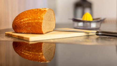 a loaf of bread on a cutting board with a knife at Apartment Neuper in Bad Mitterndorf