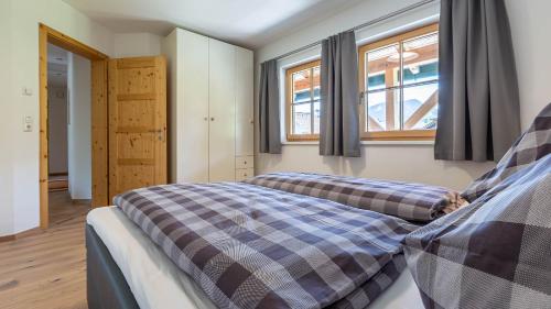 a bedroom with two beds and two windows at Apartment Neuper in Bad Mitterndorf