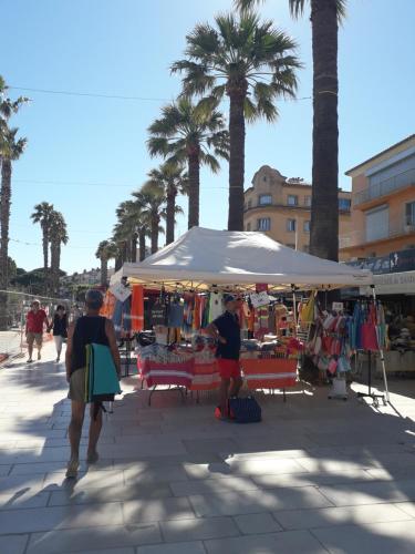 zwei Menschen, die mit einem weißen Regenschirm um einen Markt laufen in der Unterkunft LA GRANDE MAISON centre in Bandol