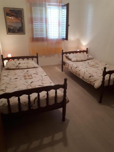 奈維斯的住宿－Apartments Njivice Bajcic，带窗户的客房内设有两张单人床。