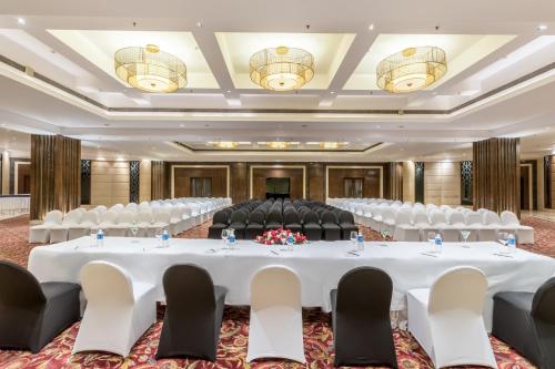 a conference room with a large white table and chairs at Golden Tulip Chandigarh, Panchkula in Chandīgarh
