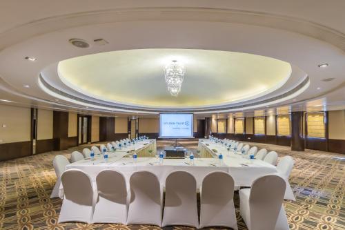 a conference room with tables and chairs and a screen at Golden Tulip Chandigarh, Panchkula in Chandīgarh
